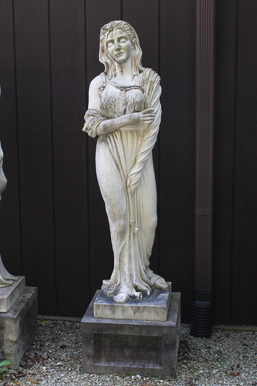 Set of cast limestone statues on pedestals.