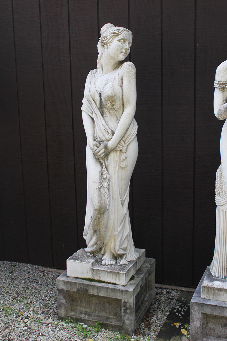 Set of cast limestone statues on pedestals.