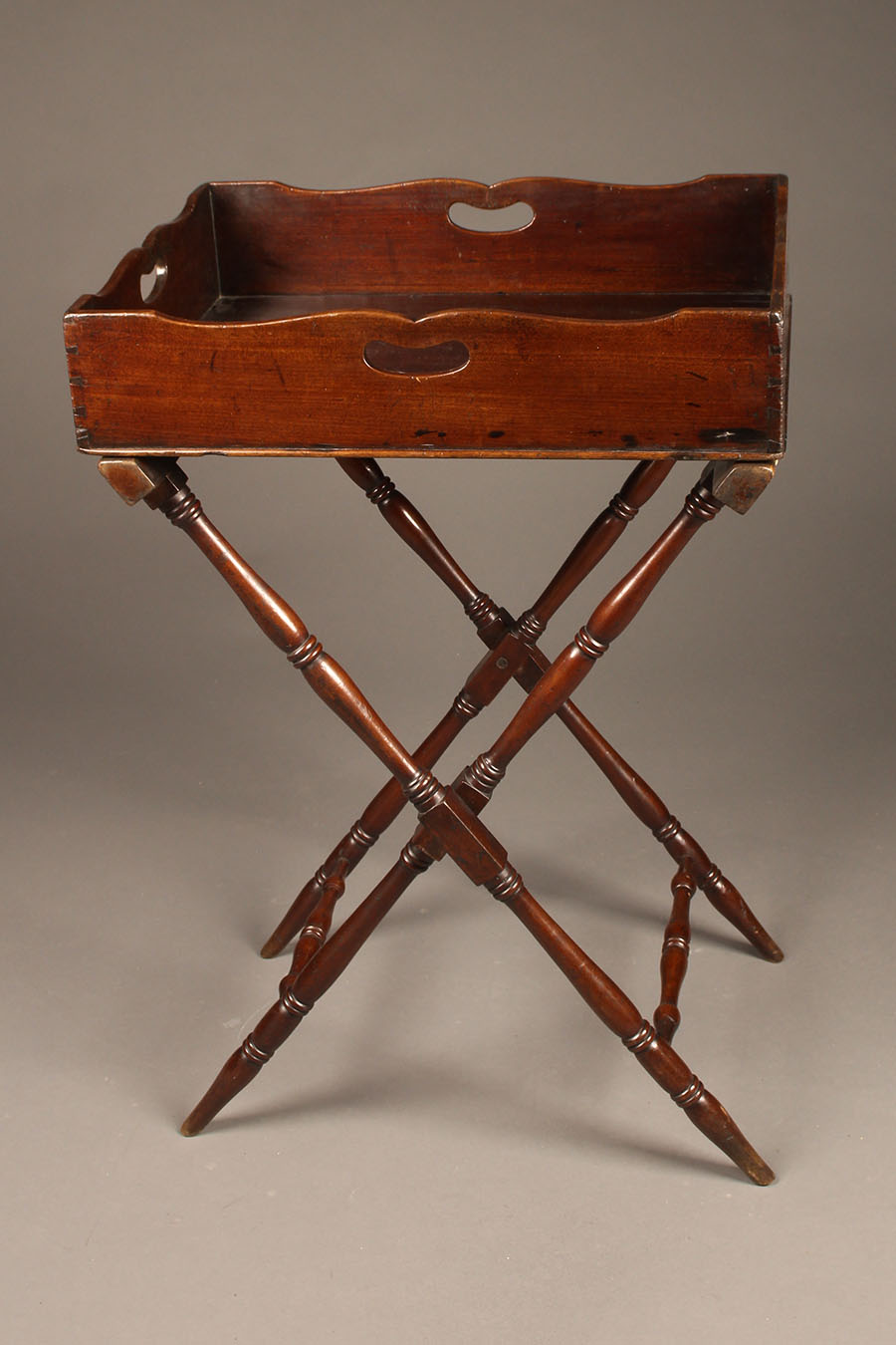 Antique butler's table in mahogany and folding base.