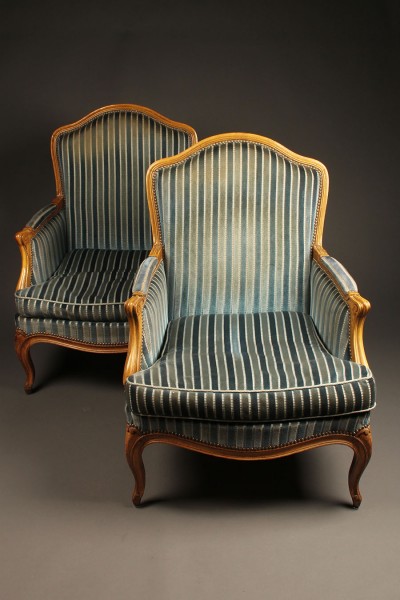 Pair of French Louis XV style bergére chairs with hand carved frame and wood pegged construction