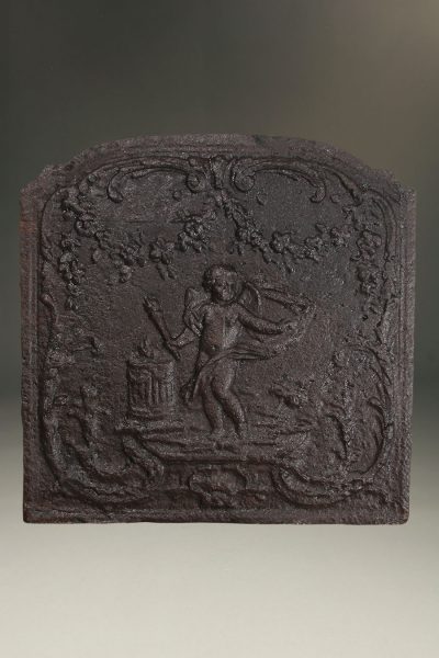 Late 17th century Flemish cast iron fireback with a cupid holding a torch standing in foliage.